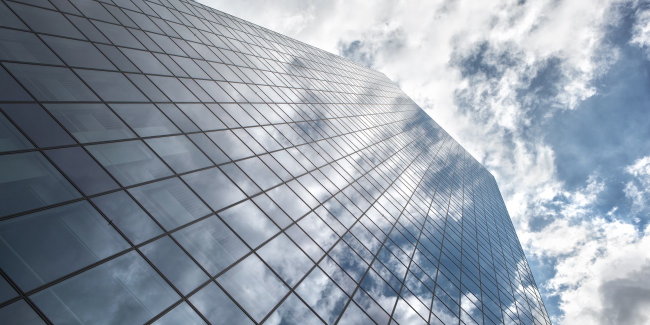 Exterior of building with with clouds reflecting in windows