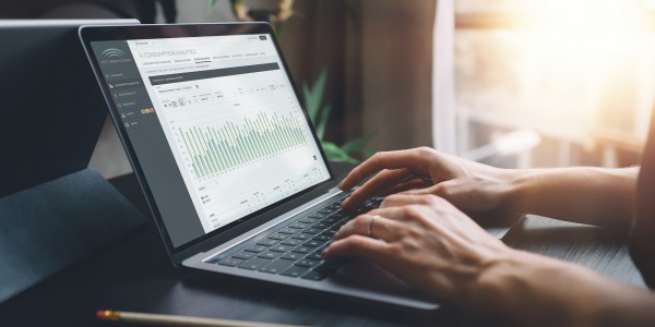 Person using laptop showing power consumption analytics